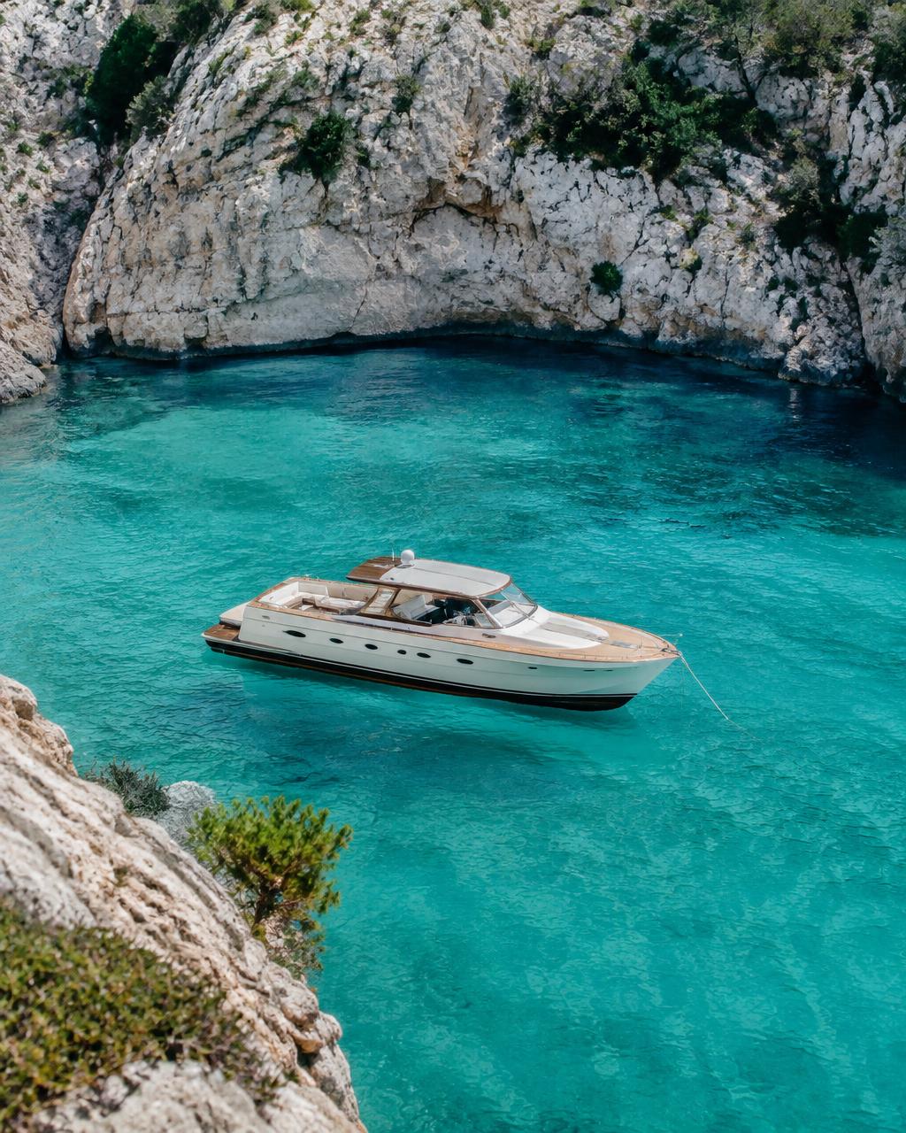 An elegant yacht anchored in a turquoise Mediterranean cove